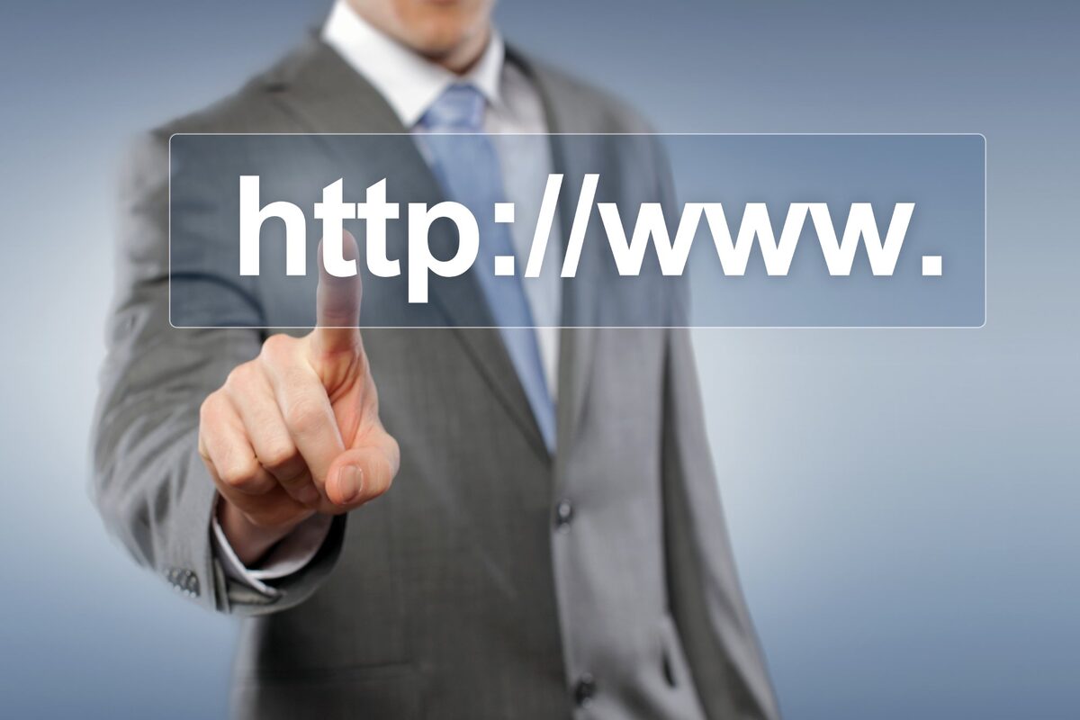 Premium Domain registrieren – Geschäftsmann tippt auf Webadresse